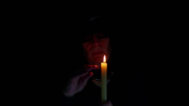 Baljós öreg ember karneváli jelmezben Halloween boszorkány, hogy mágikus rituálék gyertya — Stock videók