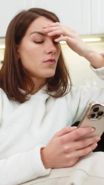 Evde genç bir kadın telefondaki haberleri aktarıyor. Sıkıntı yorgunluğu, stres, düşük enerji ve düşük motivasyon hissediyor. Kanepede oturan beyaz kız kaşlarını çatar iç çeker, tükenmiş ruh hali hisseder, telefonu beklemeye alır..