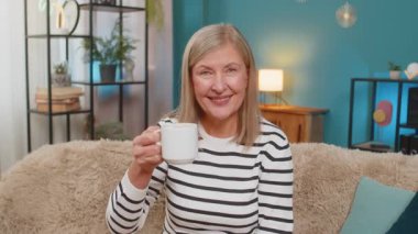 Beyaz, olgun bir kadın elinde bir fincan kahveyle kanepede otururken gülümseyerek kadeh kaldırıyor ya da minnettarlık, evdeki jestlere tezahürat yapıyor. Büyükanne sabahları sıcak bir şeyler içiyor, dinlenmenin tadını çıkarıyor.