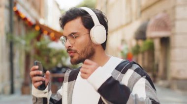 Neşeli, gevşemiş Hintli genç adam dışarıda dans eden enerjik disko rock n roll müziğini dinliyor. İspanyol adam kablosuz kulaklıklarını çıkartıyor. Şehrin sokaklarında gülümseyen kameraya bakıyor..