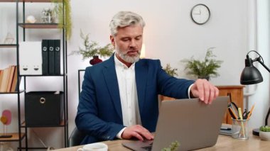 Merkez ofisteki orta yaşlı işadamı, üretken iş akışını hızlandırmak için dizüstü bilgisayar açıyor. Masa tipleri toplantısındaki serbest çalışan eleman iş bitiş tarihlerini takip ediyor, çıktıyı artırıyor..