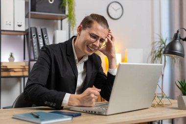 Genç, üzgün, stil sahibi bir iş adamı dizüstü bilgisayarda arama yapıyor, beklenmedik piyango sonuçlarını kaybediyor, servet kaybı, ofis masasında kötü haberler. Takım elbiseli, Kafkasyalı serbest çalışan.