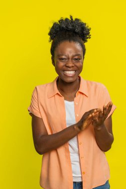 Aferin, aferin. Kadın sevinçle gülerken el çırpıyor, memnuniyet saçıyor ve alkışlıyor. Başarılı bir iş. Neşeli siyahi kız başını sallayarak başarıyı kutluyor.