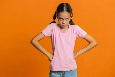 Tatminsiz genç kız çocuğu, kuşkularını dile getiriyor. Sıkılmış, gergin, sonuç konusunda hayal kırıklığına uğramış, kötü haber, başarısız, oyunu kaybetmiş. Turuncu arka planda izole edilmiş genç çocuklar