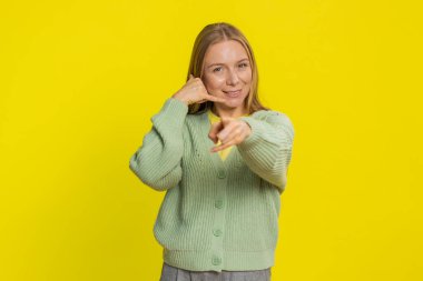 Ara beni, bu iletişim numarası. Beyaz, orta yaşlı, olgun bir kadın kameraya bakıyor. Telefon jesti yapıyor, konuşmak istiyor. Çevrimiçi hizmet teklifi ilanı sarı arka planda