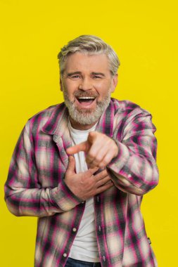 Beyaz, orta yaşlı, sarı arka planda, şaşırtıcı bir şekilde haykırışları bulaşıcı bir kahkahaya dönüşen yetişkin bir adam. Şoktan mutluluğa ani geçiş yoğun komedi duygusunu yakalar