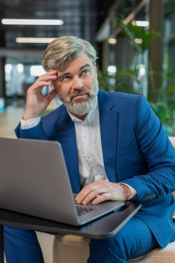 Modern ofis lobisinde dizüstü bilgisayarla çalışan sıkıcı, uykulu, olgun iş adamı. Yorgun, Kafkasyalı, serbest çalışan, takım elbiseli bir işkolik. İstihdam, meslek, işsiz.