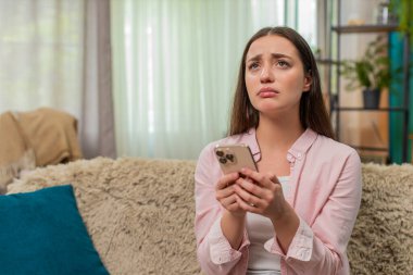 Kanepede oturan genç bir kadın maçı kaybettikten sonra üzgün üzgün gözlerle akıllı telefona bakıyor ve hayal kırıklığına uğruyor. Kafkasyalı kız üzgün ve ümitsiz hissediyor ve sakinleşmek için nefes alıyor..