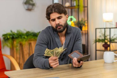 Evdeki Hintli adam cüzdanı açar. Sadece küçük bozuk paralar görür. Faturalar ve düşük maaşlar için endişelenir. Masa başı bütçesi olan Arap bir adam para sayıyor. Fakirlik ve gecikme faturaları hakkında düşünüyor.