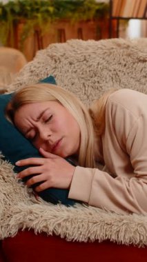 Genç yetişkin bir kadın aniden kanepede uyanıyor, hızlı nefes alıyor ve gözle görülür bir korkuyla tepki veriyor. Sarışın kız duygusal stres gösteriyor, korku ve gerilim gösteren kabus üstüne şok yaşıyor.