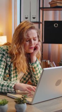 Sıkıcı genç sarışın iş kadını dizüstü bilgisayarda çalışıyor, esniyor, ofis masasına yaslanıyor. Yorgun, serbest çalışan, işkolik bir kız. İstihdam, meslek, işsiz.