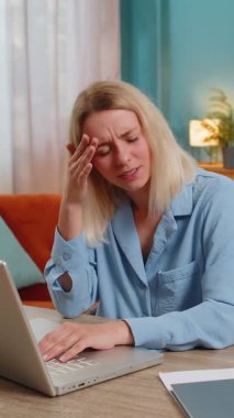 Baş ağrısı, gerginlik, migren, iş yerindeki stresten muzdarip yorgun genç iş kadını. Dizüstü bilgisayarla çalışan sarışın, serbest çalışan kadın. Fazla çalışma.