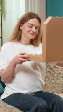 Evde orta yaşlı hamile bir kadın pizza kutusunu açıyor dilimler, ısırıklar, gülücükler, akşam yemeğinin tadını alıyor. Kanepede beyaz bir kız sıcak peynirli yemekler yiyor. Büyük bir rahatlık. Açlığı besliyor..