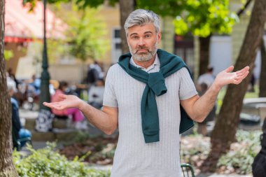 Ne diyecegimi bilmiyorum. Kafası karışmış olgun bir adam, belirsiz bir soru hakkında utanmış, kuşkuları olan, hiçbir fikri olmayan, açık havada bilgisiz bir adam. Şehir caddesinde dikilen beyaz yetişkin adam.