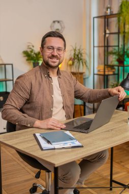 Kafkas genç iş adamı dizüstü bilgisayarı açıyor ve ofis masasında otururken proje üzerinde çalışıyor. Yetişkin adam internet üzerinde çalışıyor, mesajlar gönderiyor, online alışverişler yapıyor, film izliyor..