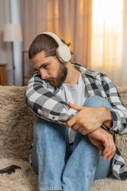 Genç adam evde oturup kulaklık takıyor, duygusal melodiler dinliyor, göz yaşlarına karşı savaşıyor. Kanepedeki adam kulaklıkları çıkarıp acı dolu bir ayrılık ya da ayrılık için iç çekiyordu. Boşanma