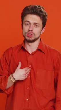 Hiçbir şey söylemeyeceğim. Korkmuş genç adam elleriyle ağzını kapatıyor, kamera karşısında korkmuş görünüyor hayır, korkunç bir sırrı anlatmayı reddediyor inanılmaz bir gerçeği. Turuncu arka plandaki adam