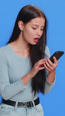 Mutlu, mutlu, neşeli bir kadın akıllı telefon daktilo kullanıyor. 