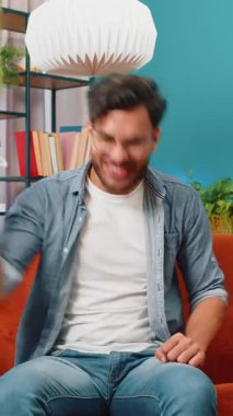 Mutlu Hintli adam bağırıyor, başarıyı kutluyor, kazanıyor, gol başarısı iyi haber piyango talihi zaferi, modern ev dairesinde TV şampiyonluğu izliyor. Oturma odasında oturan Arap adam.