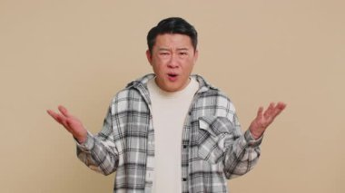 - Ne? - Neden? Kızgın, kafası karışmış Asyalı bir adam öfkeli bir ifadeyle el kaldırarak başarısızlık sebebini soruyor, sorunlardan kuşkulandığını gösteriyor. Orta yaşlı Çinli adam bej arka planda izole edilmiş.