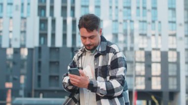 Zengin, olgun, beyaz iş adamı turist akıllı telefon kullanıyor ve şehir merkezinde nakit para sayıyor. Başarılı iş kariyeri, piyango kazananı, büyük gelir, zenginlik.