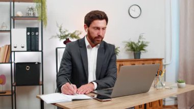 Merkez ofisteki orta yaşlı işadamı dizüstü bilgisayarda kulaklık takıp notlar alıyor ve gülümsüyor. Masadaki serbest çalışan adam ekranın akıllı telefon fotoğrafını çekiyor ve bugün slaytı değiştirmek için tuşa basıyor..