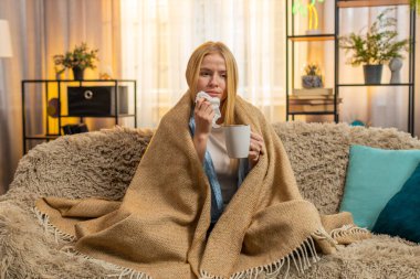 Genç bir kadın evinde battaniyenin altına saklanıyor, sıcak çayını yudumluyor ve burnunu mendille siliyor. Kanepedeki beyaz kız hafif bir hastalık evresinde rahatlık ve rahatlama arayışında soğuk semptomlara katlanıyor..