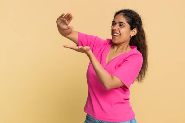 Hintli kadın sevinçle hayali paraları savuruyor, parlak bir şekilde gülümsüyor, finansal başarıyı kutluyor. Arap kız mutlu bir şekilde zenginliğini, refahını, harcamalarını ya da finansal hedefine ulaşmasını gösteriyor.