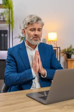 Merkez ofisteki orta yaşlı işadamı dizüstü bilgisayarın anahtar sistemini çökertti ve acilen iyileşmesi için dua etmeye başladı. Masadaki serbest çalışan eleman son teslim tarihlerini ve hayati verileri yeniden başlatmayı umuyor.