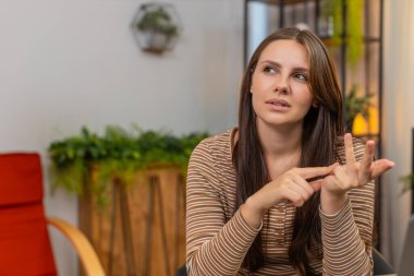 Evdeki genç kadın parmaklarıyla görevleri sayıyor parmaklarını katlıyor ve sakin bir şekilde listeyi kontrol ediyor. Masadaki beyaz kız ilerlemeyi gözden geçiriyor rakamlar not yazıyor ve sonraki adımları sakin bir ruh haliyle planlıyor.