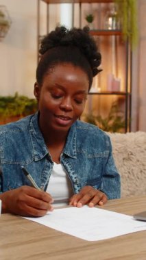 Afro-Amerikalı genç bir kadın ilk iş sözleşmesini ya da faturayı gururla imzalar. Siyahi kız önemli başarılarını kutluyor kariyerine özgüvenle başlıyor