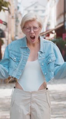 Hayal kırıklığına uğramış, omuz silken, üzgün, genç, sarışın bir kadın. Cevap vermiyor. Tepkisi belirsiz..