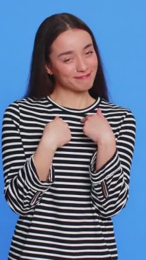 Bana para ver lütfen. Kafkasyalı genç bir kadının parmaklarını ovuşturması borçlarını ödemek için nakit para talep ettiğini gösteriyor. Borç al, alışveriş yap, yatırım için yalvar. Stüdyo mavi arka planda izole edilmiş kız