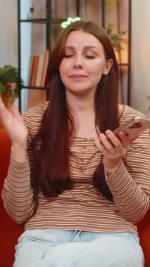 Evdeki genç kadın akıllı telefon hoparlörü kullanıyor. Açık sesli konuşuyor. Planı açıklıyor ve sakin kalıyor. Kanepede oturan beyaz bir kız başını sallar onaylar ve kibarca güler.