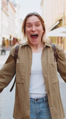 Mutlu genç bir kadın bağırıyor, başarıyı kutluyor, gol başarısını kutluyor, iyi haberler, piyango kumarhanesi büyük ikramiyesi, zafer, başparmağını göster. Şehirli caddedeki heyecanlı kız. Kasaba yaşam tarzları