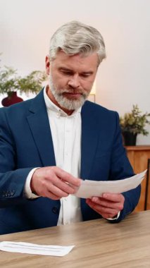 Merkez ofisteki orta yaşlı işadamı ödenmemiş faturaları biriktirip baskı hissedip sonra da onları bir kenara atıyor. Masadaki serbest çalışan adam, acil borçlardan kurtulmak için masraf kesintileri planlıyor..