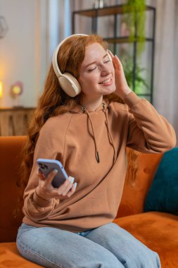 Kablosuz kulaklıklı, mutlu, genç, kızıl saçlı bir kadın evinde koltukta oturup en sevdiği enerjik disko dans müziğini dinliyor. İnsanlar hafta sonları boş zaman aktiviteleri yapar. Dikey