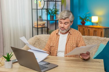 Beyaz, olgun bir adam evrak faturalarıyla çevrili masada oturuyor. Orta yaşlı bir adam mali zorluklar yüzünden hayal kırıklığına uğramış görünüyor. İflas sorunları çözmek için mücadele ediyor.