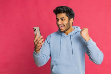 Mutlu Hintli genç adam akıllı telefon daktilo kullanıyor ve bağırıyor 