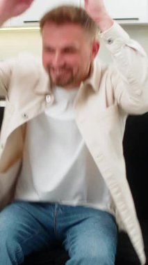 Evdeki genç adam arkasını yaslar ellerini başının arkasına koyar ve yavaş bir nefes alıp tansiyonu düşürür. Kafkasyalı adam kanepeye uzanır, hafifçe gözlerini kapatır ve sakin bir rahatlık ve uykusunu gösterir.