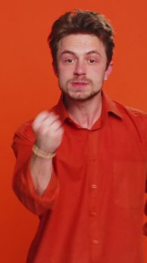 Saldırgan sinirli Kafkasyalı genç adam kameraya karşı dövüşmeye çalışıyor, yumruk tokalaşıyor, ifadeyle boks yapıyor, cezalandırıyor, tehdit ediyor, taciz ediyor, öfkeden kuduruyor. Yakışıklı adam turuncu stüdyo geçmişinde izole edilmiş.