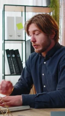 Sıkıcı genç iş adamı dizüstü bilgisayarla çalışıyor, ofis masasında göz çimdikliyor. Yorgun, Kafkasyalı, serbest çalışan, işkolik bir adam. İstihdam, meslek, işsiz.