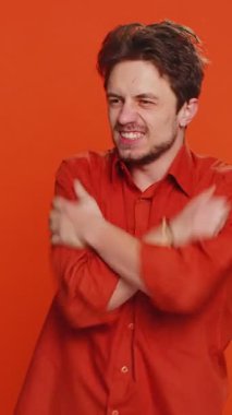 Sinirli, sinirli, Kafkasyalı bir adam kızgın bir ifadeyle ellerini kaldırıyor, çatışma nedeni sorguluyor, neden bu kadar inatçısın? Sinirli genç adam turuncu arka planda kapalı yerde izole edilmiş.