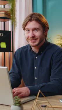 Hoş geldiniz. Kafkas 'lı mutlu iş adamı el sallayarak selam veriyor. Birine hoş geldin diyor. İnternetteki Webinar, uzaktan konuşma. Ofisteki bilgisayarı kullanarak masada oturan serbest çalışan bir adam..