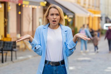 Ne diyecegimi bilmiyorum. Kafası karışmış genç bir kadın belirsiz bir sorudan utanıyor. Kuşkuları var. Açık havada ne kadar bilgisiz olduğu hakkında hiçbir fikri yok. Şehir caddesinde dikilen beyaz kadın.