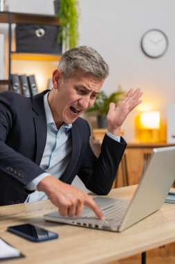 Sinirli işadamı dizüstü bilgisayarla ilgili yazılım sorunları yaşıyor, sinirli adam sinirleniyor, hata görüyor veya bilgisayar ekranında hata bildirimi yapıyor, deli çalışan virüs saldırısı ya da uygulama arızası yaşıyor.