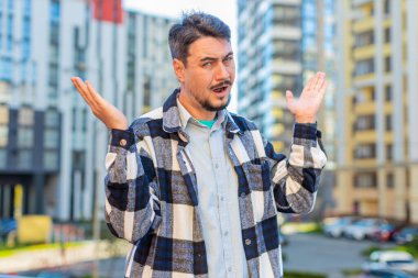 Hayal kırıklığına uğramış, olgun bir turistin omuzlarını silkmesi şüpheli. Cevap vermiyor. Tepkisi belirsiz. Zor bir soru, kafası karışmış bir adam.