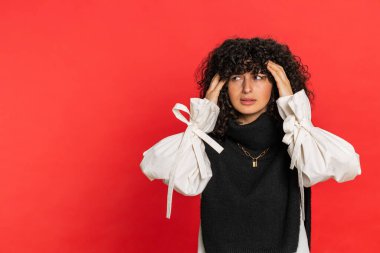 Çekici, yorgun, genç bir kız baş ağrısı problemini tedavi etmek için tapınakları ovuyor, tansiyon, migren stresi, acı içinde yüzün ekşiyor, yüksek tansiyon kırmızı duvarda tek başına.