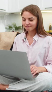 Evde genç bir kadın serbest görevleri tamamlıyor dizüstü bilgisayarı kapatıyor ve gülümseyerek arkasına yaslanıyor ve keyfine bakıyor. Kanepede oturan beyaz bir kız içerikli ruh hali sergiliyor rahatlatıcı nefes alıyor ve bir sonraki golden önce dinleniyor.