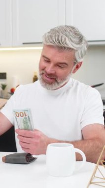 Ev sayımı yapan orta yaşlı bir adam faturalar için bir kenara para koyuyor. Kendini tatmin olmuş hissediyor. Masadaki olgun adam kontrol jesti gösteriyor. Yardım planlarıyla birlikte bütçe masraflarını karşılıyor.